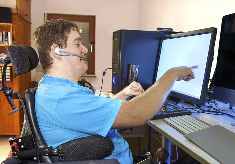 Mann mit geistiger Behinderung vor einem PC-Monitor